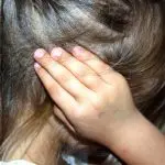 enfant émotif avec la main dans les cheveux, exprimant du stress ou de la frustration