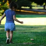 enfant qui court et joue activement dans un jardin ensoleillé