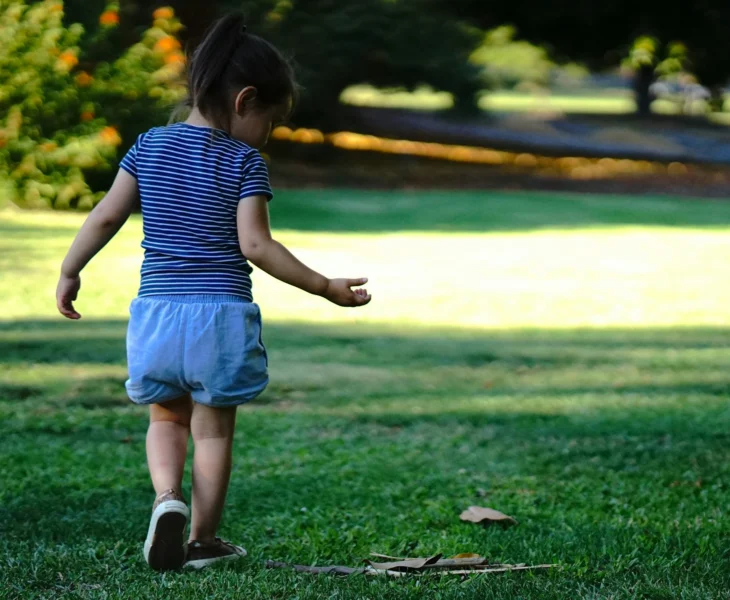 enfant qui court et joue activement dans un jardin ensoleillé