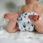 bébé portant une couche avec motif cactus coloré sur fond blanc