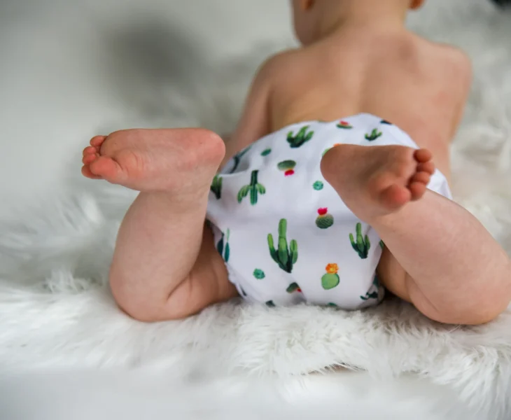 bébé portant une couche avec motif cactus coloré sur fond blanc