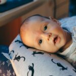 Charming infant captured tenderly indoors, showcasing innocence and warmth.