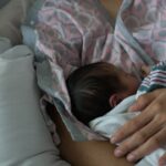 Mother holding a newborn baby while breastfeeding.