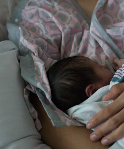 Mother holding a newborn baby while breastfeeding.