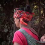 woman in red shirt with green and red floral headdress
