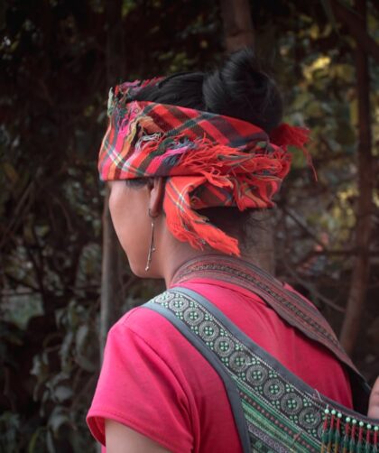 woman in red shirt with green and red floral headdress