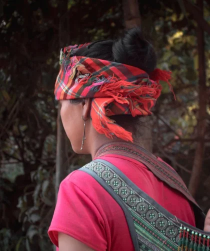 woman in red shirt with green and red floral headdress